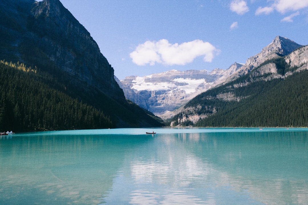 Turquoise lake reflecting mountains and sky