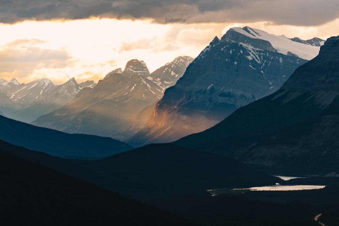 Mountains emerge from the shadows under a dramatic sky.