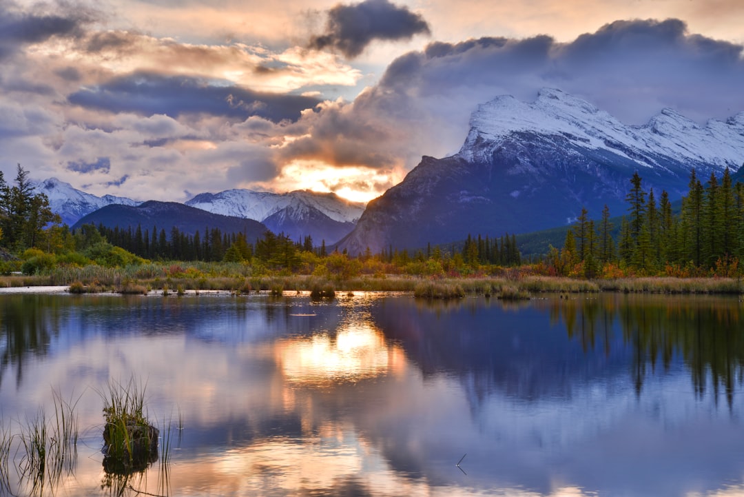 Majestic mountain range reflected in a tranquil lake at sunset.
