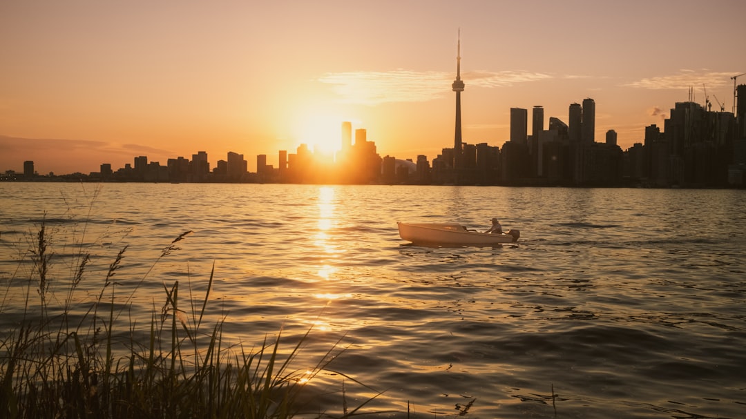 A boat cruises during a beautiful sunset over the city.