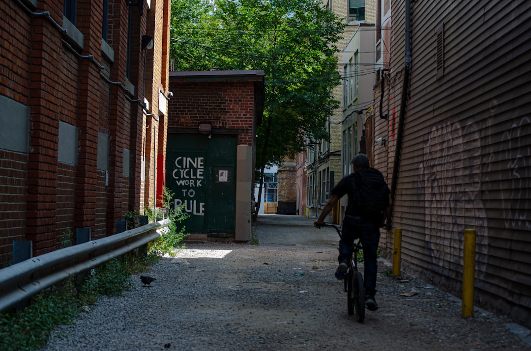 man in black jacket and black pants walking on sidewalk during daytime