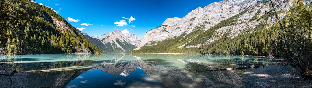 Stunning mountain lake reflecting rocky peaks and blue sky.