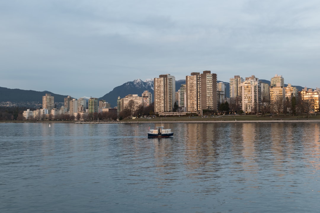 a boat floating on top of a lake next to tall buildings a boat floating on top of a lake next to tall buildings