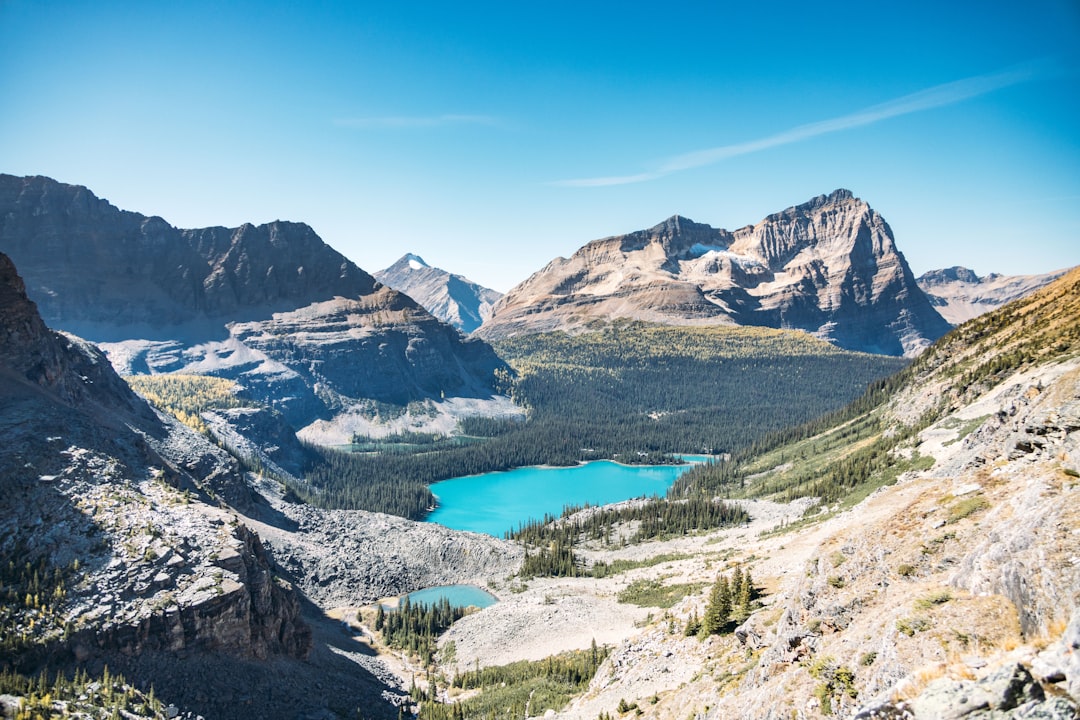 Turquoise lake surrounded by majestic mountains under a clear sky.