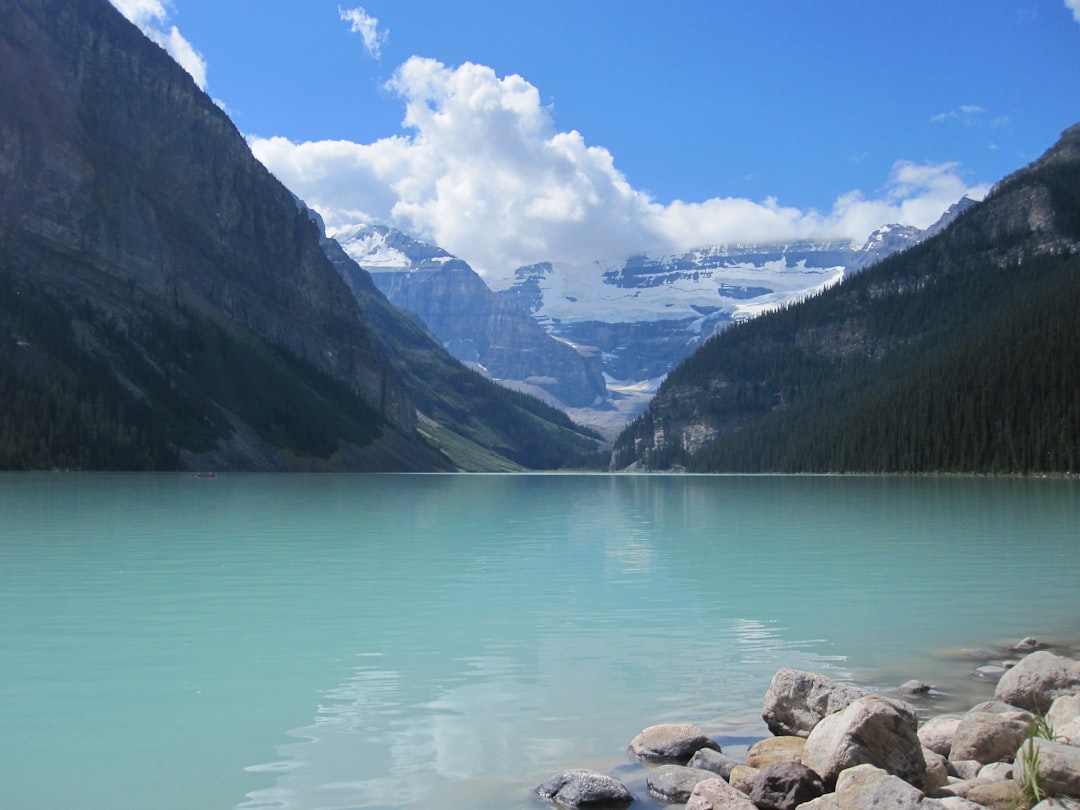 Turquoise lake surrounded by majestic mountains under a blue sky
