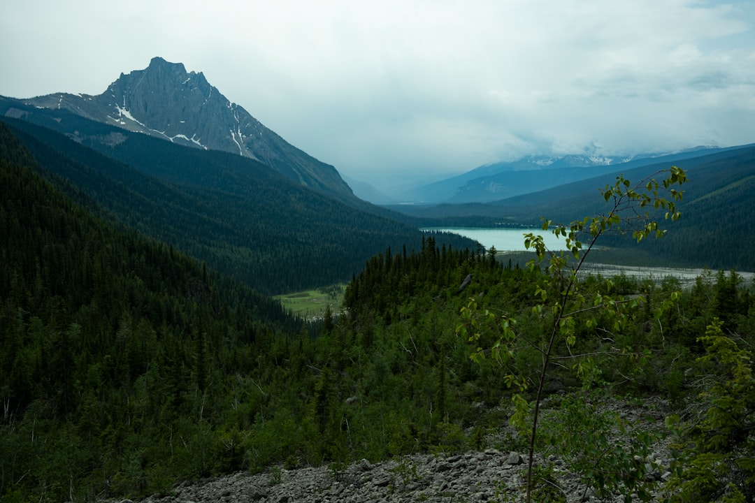 Mountain valley with a lake under cloudy sky
