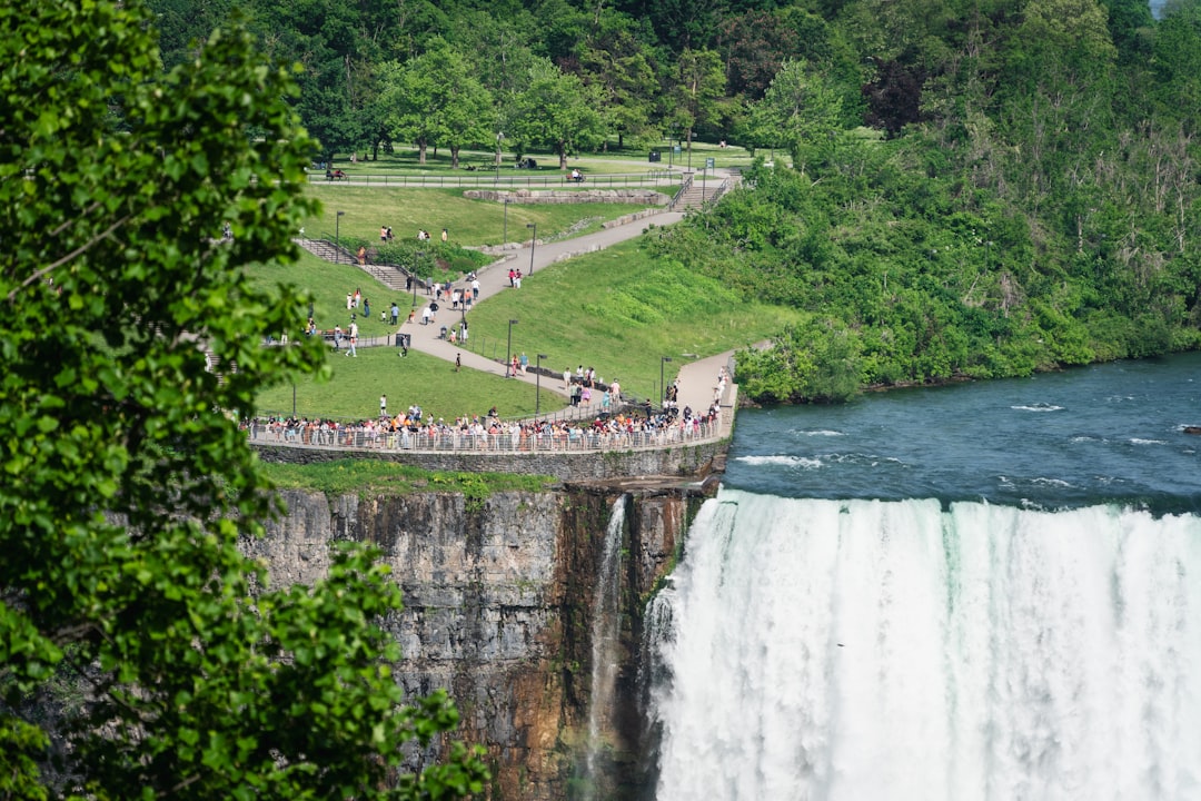 a group of people standing on a bridge over a waterfall