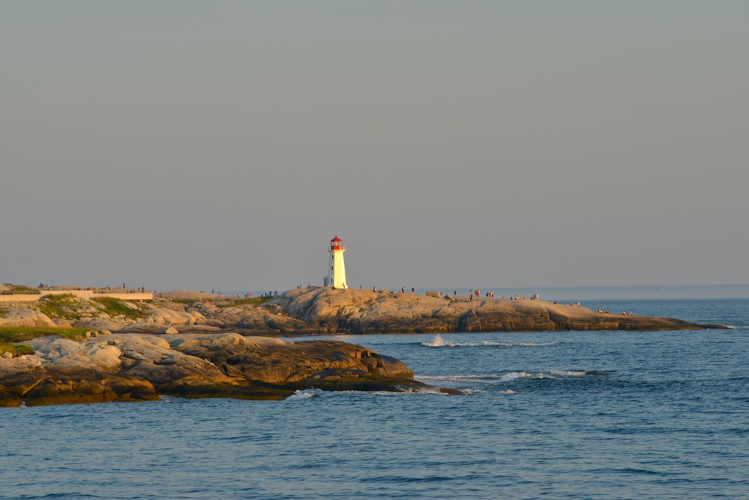 Lighthouse on rocky coast with ocean waves
