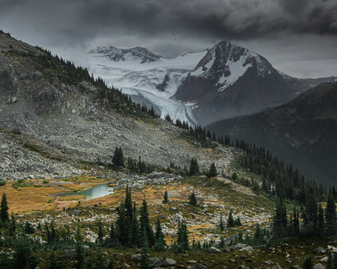 Mountains meet a glacier under cloudy skies