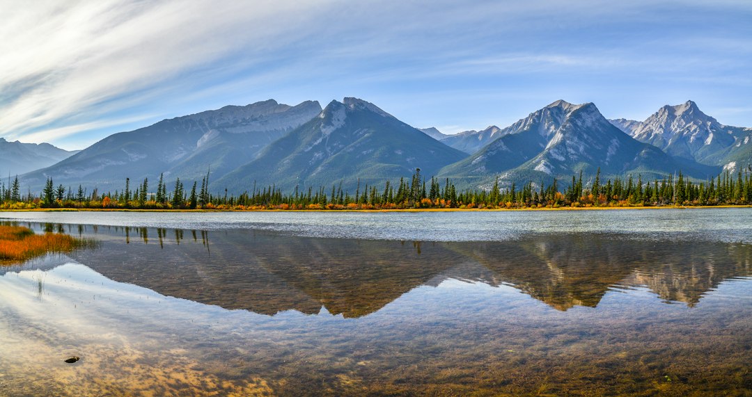 Clear lake reflects rugged mountains and blue sky