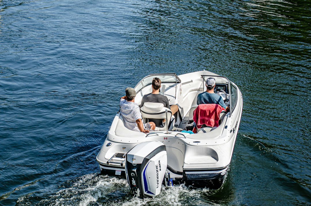 couple sitting on white and black motor boat on sea during daytime