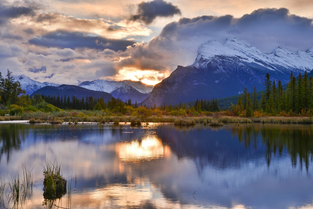 Majestic mountain range reflected in a tranquil lake at sunset