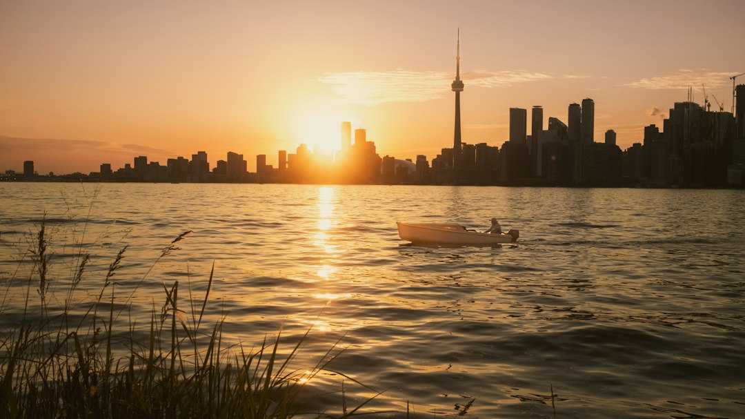 A boat cruises during a beautiful sunset over the city